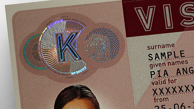 Detail of KINEGRAM PRIME security patch for visa stickers Close-Up of KINEGRAM sample security patch for protecting visa stickers showing a circular design combining metallized and printed lines