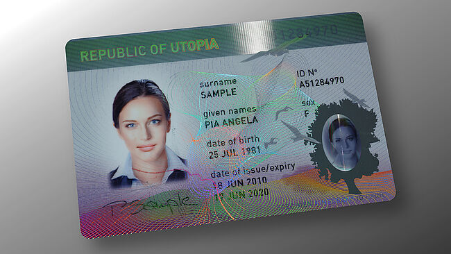 Sample ID card showing a Transparent KINEGRAM Overlay (KINEGRAM TKO) combined with KINEGRAM ZERO.ZERO partial metallization, enabling intuitive ID verification Image of a sample ID card with Transparent KINEGRAM Overlay (KINEGRAM TKO) combined with KINEGRAM ZERO.ZERO partial metallization, , enabling intuitive ID verification