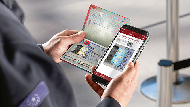 Robust and sophisticated SDK solutions and apps for various ID check purposes Image of an Officer using a smartphone to authenticate a Swiss KINEGRAM-secured passport