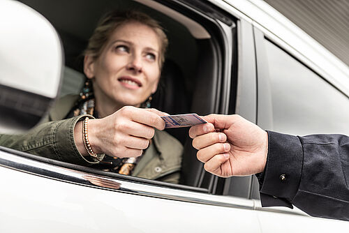 Secure government documents with KINEGRAM Person handing out his ID card to an officer through the car window